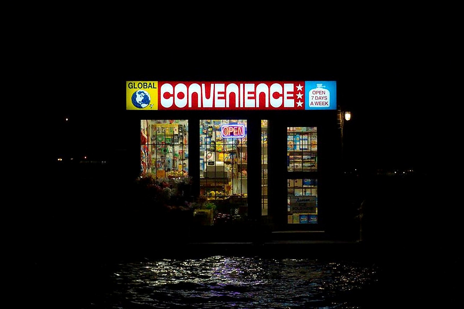 Free Illuminated convenience store reflecting on water at night in Toronto. Stock Photo